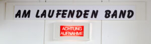 Schild "Am laufenden Band" und Leuchte "Achtung Aufnahme"